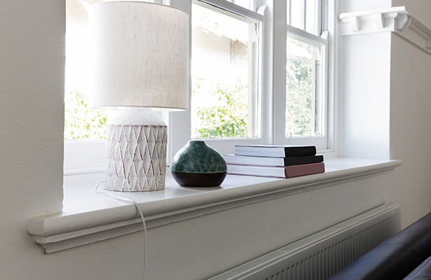    weiße Fensterbank, mit Büchern, einer Lampe und einer Vase dekoriert 